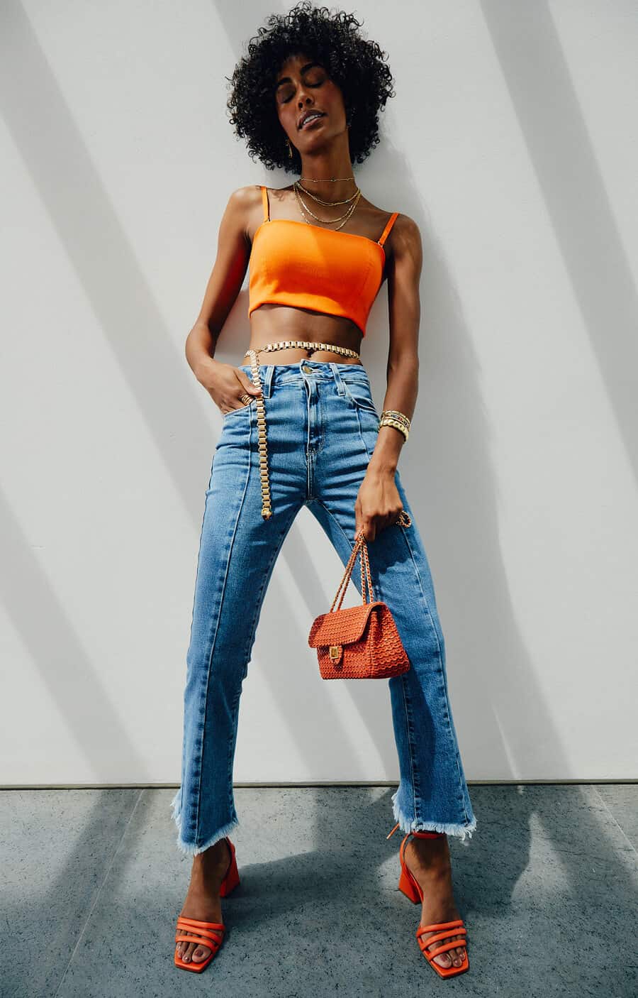 modelo com cropped, calça jeans e bolsa para usar na balada